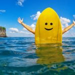 Happy surfer girl sit on yellow surfboard with smiley face